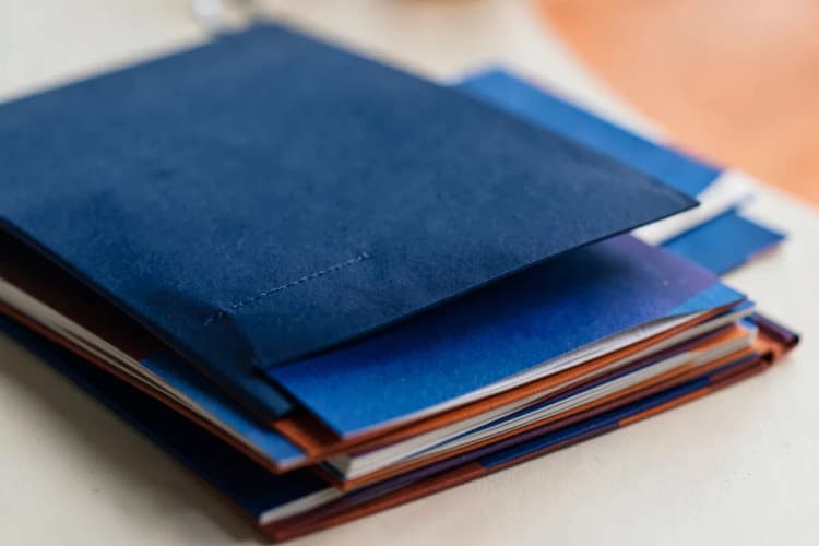 Documentos fiscais organizados em pastas, com selos e carimbos.