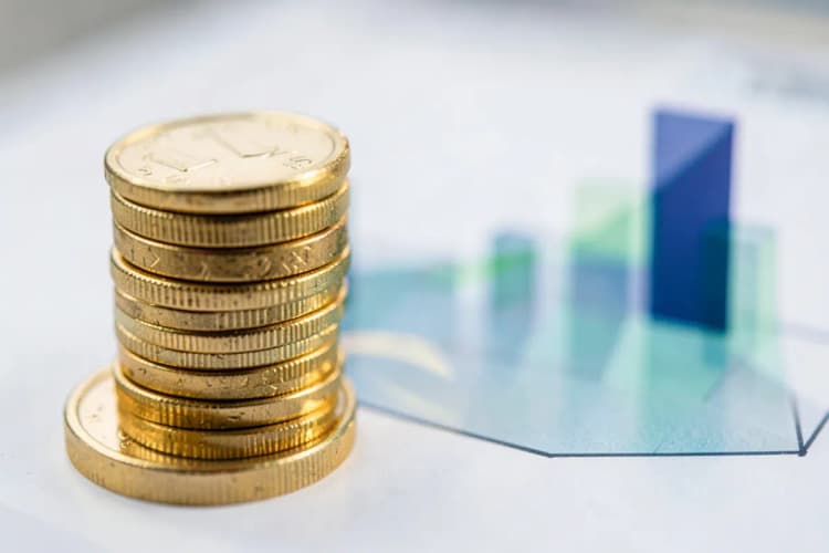 Gráfico de barras mostrando crescimento financeiro com moedas de ouro empilhadas ao lado.