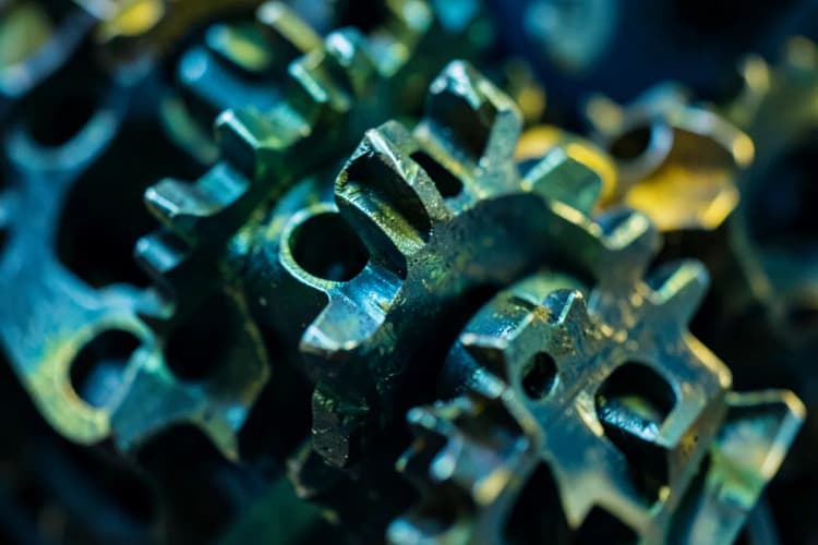 Um conjunto de engrenagens metálicas interligadas girando suavemente, representando a eficiência e o bom funcionamento de um sistema automatizado.